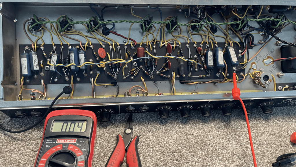 Cómo Probar Fugas Condensadores de Audio en un Amplificador a Válvulas 2 Técnico midiendo tensión de corriente continua (DC) en amplificador de audio con sondas de multímetro digital para detectar fugas de condensador. Probar fugas condensadores