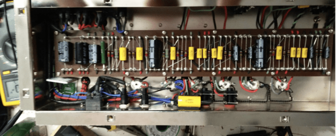 Interior de amplificador valvular mostrando condensadores de poder con fugas - prueba técnica de condensadores