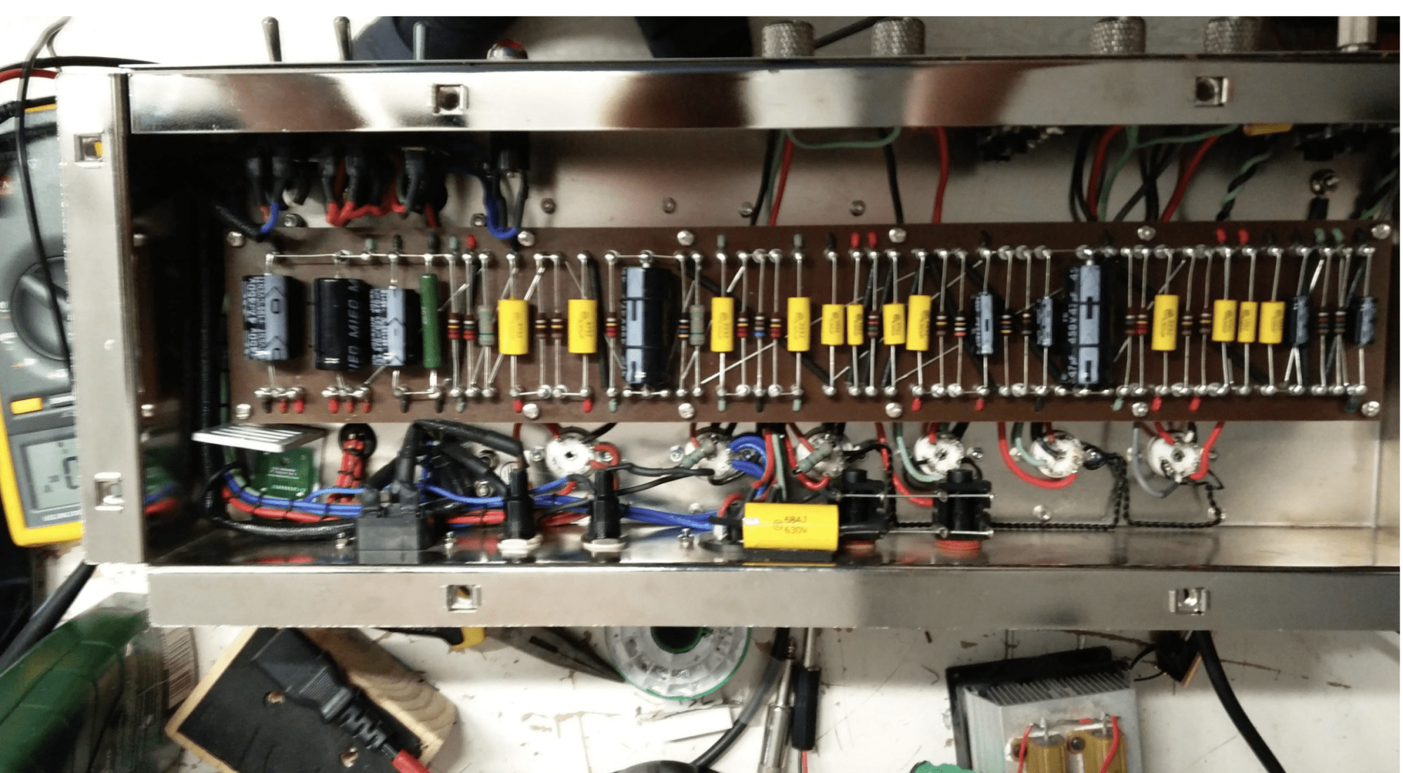 Interior de amplificador valvular mostrando condensadores de poder con fugas - prueba técnica de condensadores